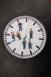 Eine Uhr umgeben von vielen kleinen Arbeitermaennchen....