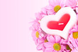 Candle in the shape of a heart and chrysanthemums.