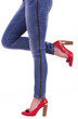 Sexy womanish leg in blue jeans and red shoes