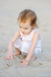 Adorable toddler girl playing on the beach