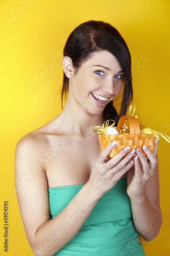 Photo: smiling woman with eggs on easter in a basket smiling woman with eggs on easter in a basket