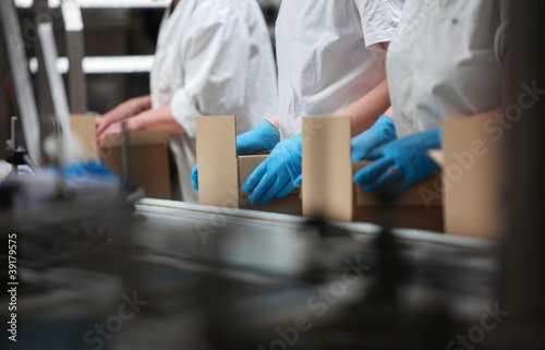 Photo: people working on packing line in factory people working on packing line in factory