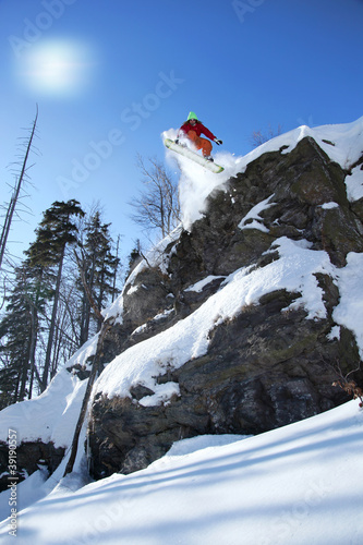 Photo: Snowboarder jumping against blue sky Snowboarder jumping against blue sky