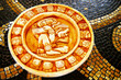 Carved stone Mayan calendar on tile background