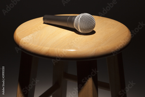 Photo: Microphone Laying on Wooden Stool Under Spotlight Microphone Laying on Wooden Stool Under Spotlight
