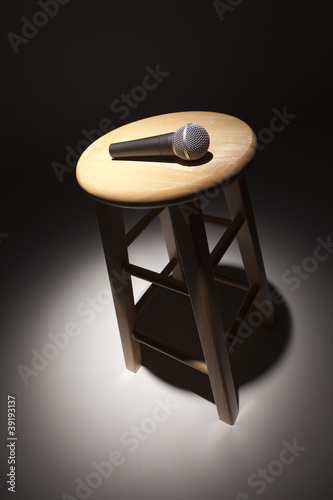 Photo: Microphone Laying on Wooden Stool Under Spotlight Microphone Laying on Wooden Stool Under Spotlight