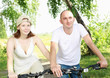 Photo: Young couple on the bikes in the park Young couple on the bikes in the park