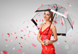 Pretty woman under umbrella with petals around her