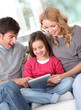 Photo : Happy family at home using electronic tablet Happy family at home using electronic tablet