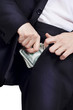 Businessman is putting money in his pocket