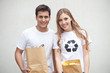 Couple holding paper garbage bags