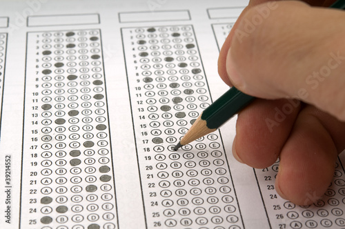 Photo: Student filling out answers to a test with a pencil Student filling out answers to a test with a pencil