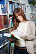 young student girl reading book in library