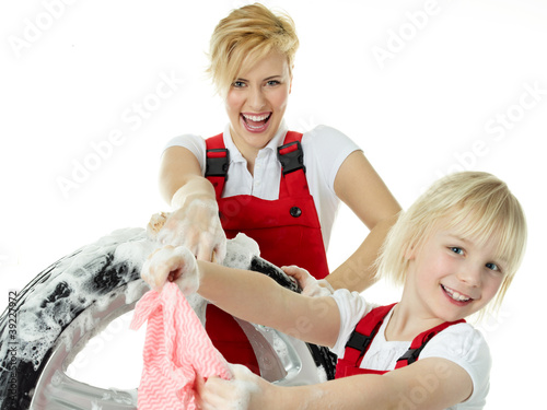 Foto: Blonde sisters wearing overalls washing a wheel Blonde sisters wearing overalls washing a wheel