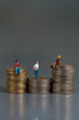 Spielzeugfiguren sitzen auf Geld