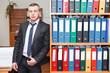 Handsome male business executive standing behind a bookstand