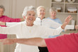 Seniors doing arm strengthening exercises in a health club