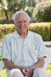 Portrait of a senior man sitting on a park bench and smiling