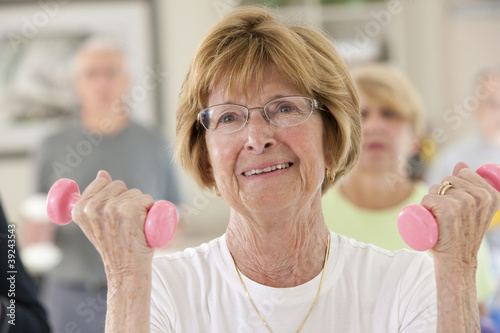 Photo: Seniors exercising with dumbbells in a health club Seniors exercising with dumbbells in a health club