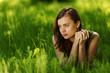 brunette lying on green grass