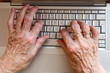 ältere Hände auf Computertastatur
