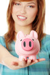 Young teen woman showing her pink piggy bank
