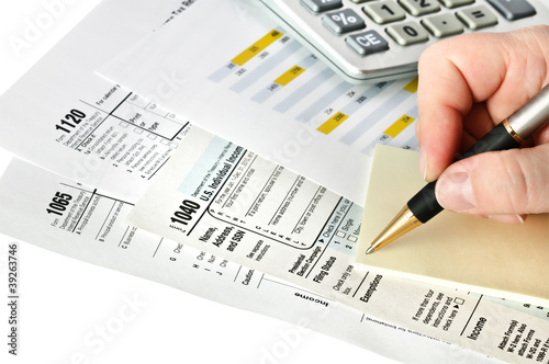 Photo: Financial forms with pen, calculator and sticker. Isolated. Financial forms with pen, calculator and sticker. Isolated.