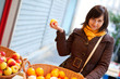 Beautiful young customer selecting apples at market