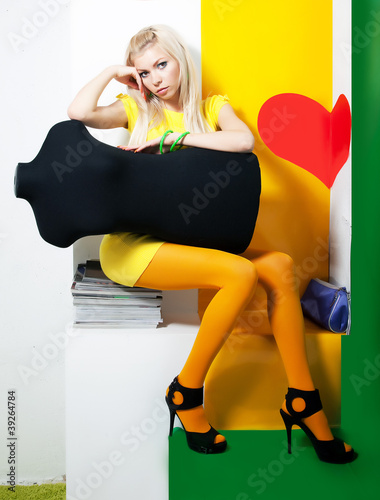 Photo: Elegant woman blonde in studio with black mannequin Elegant woman blonde in studio with black mannequin