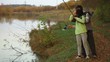 Young couple in love learns fishing at sunset