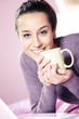 Portrait of a pretty happy young woman holding a cup of coffee