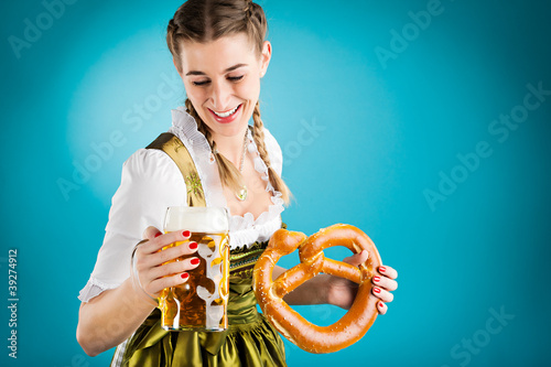 Photo: Junge Frau in Dirndl mit Bier und Bretzel Junge Frau in Dirndl mit Bier und Bretzel