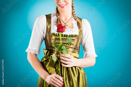 Photo: Junge Frau in Dirndl mit roter Rose Junge Frau in Dirndl mit roter Rose