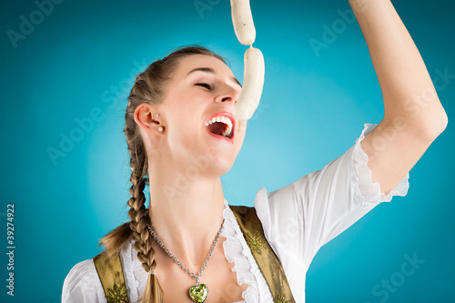 Photo: Junge Frau mit Weisswurst im Dirndl Junge Frau mit Weisswurst im Dirndl