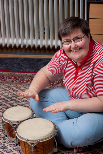 Photo: Geistig behinderte Frau trommelt auf Bongos und ist glücklich Geistig behinderte Frau trommelt auf Bongos und ist glücklich