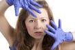 Überraschte junge Frau mit blauen Handschuhen