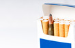 open pack of cigarettes with a weapon cartridge