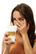 frau mit latte macchiato versteckt ihr gesicht hinter ihrer hand