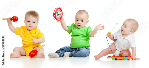 Photo: Children playing with musical toys. Isolated on white background Children playing with musical toys. Isolated on white background