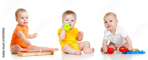 Foto: Children playing with musical toys. Isolated on white background Children playing with musical toys. Isolated on white background
