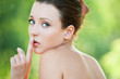 Naked woman holding finger near lips
