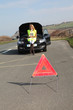 Warning triangle set on the road by broken down car Warning triangle set on the road by broken down car