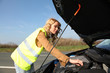 Woman checking on car engine breakdown Woman checking on car engine breakdown