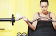 gym: portrait of  young woman lifting weights