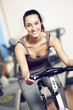 Photo: A young woman riding an exercise bike A young woman riding an exercise bike