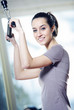 smiling young woman doing on a weight machine at the health club