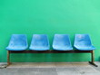 Blue Seats against green wall . Blue Seats against green wall .