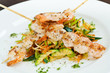 Shrimp on skewers on top of assortment of vegetables