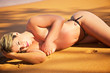 Golden Blonde Bikini Girl topless laying on the sand beach