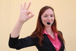 Redhead young woman with headset gesturing OK